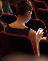 6113-07160098 © Masterfile Royalty-Free Model Release: Yes Property Release: Yes Rear view of woman using cell phone in theater audience