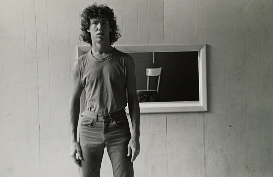 John Bernd in the 1980s, photographed by Dona Ann McAdams in front of am image of his red chair