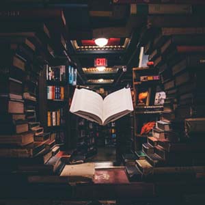 Photo of a floating book in a stack of other books.
