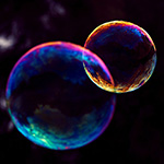 Photo of two soap bubbles against a black backdrop.